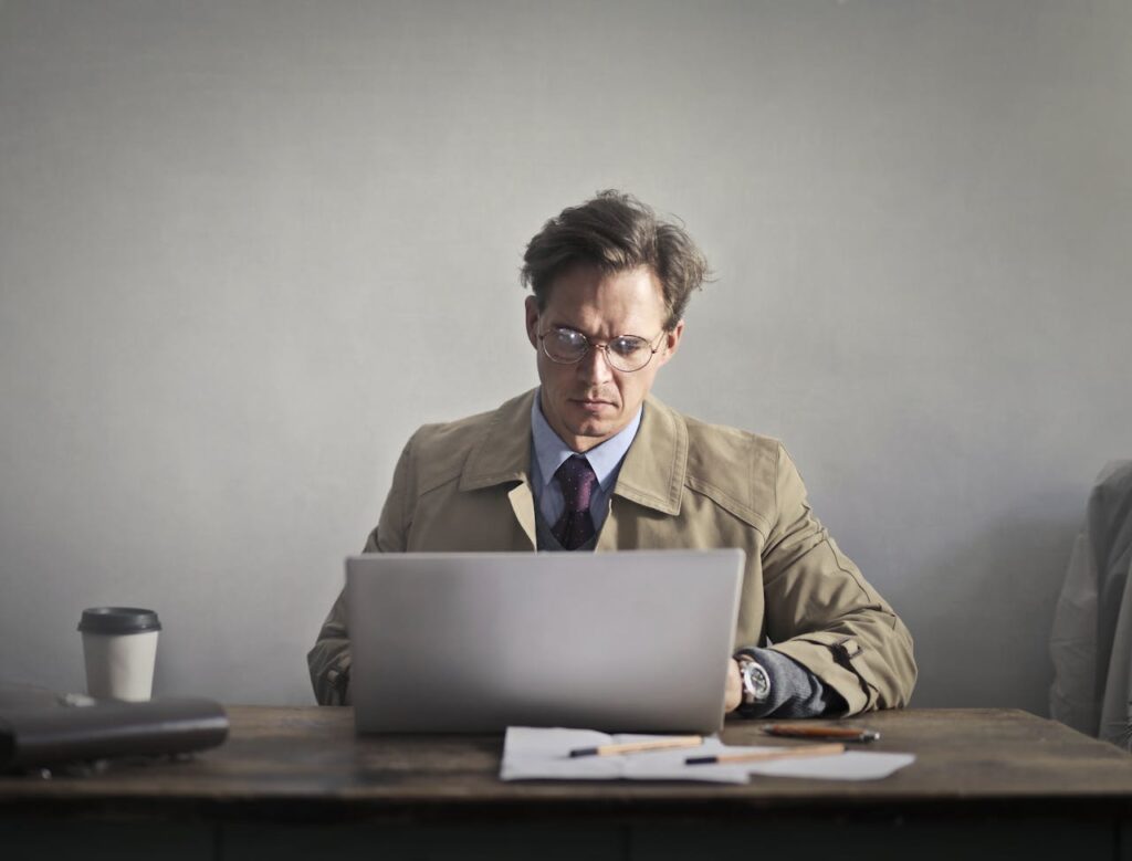 man looking stressed infront of laptop at desk